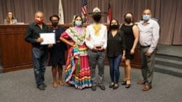 Teótl Foundation members lined up in group photo with Chairwoman Lisa Cupid. Two of the members are dressed in traditional Mexican dancer's garb