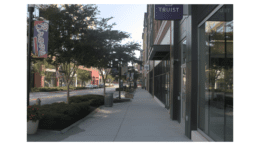 A sidewalk lined with storefronts in The Battery