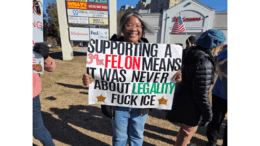 Woman holding sign protesting ICE at a rally at Home Depot