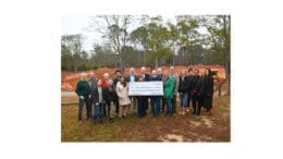 Group photo of people from non-profits with a giant display check