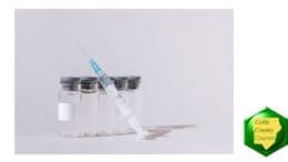 A syringe with five vials of clear liquid